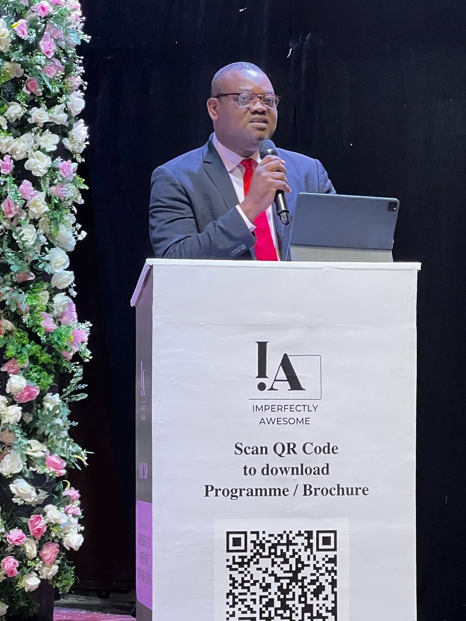 Amos Ologunleko speaking from a podium